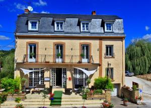 a large brick house with a balcony at Logis Hôtel Restaurant Le Lascaux in Montignac