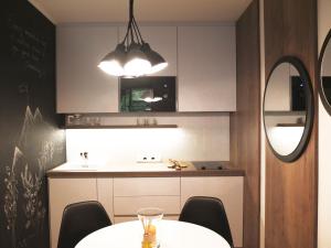 a kitchen with a table and chairs and a mirror at Sun Valley Apartment in Bad Hofgastein +21 photos