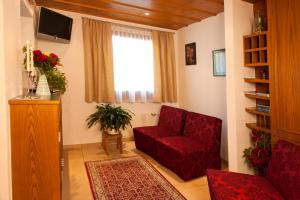 a living room with a red chair and a window at Hotel Romantica in Samnaun