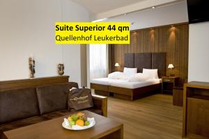 Hotel Quellenhof Leukerbad في لوكرباد: غرفة في الفندق بها سرير وطاولة مع وعاء من الفواكه