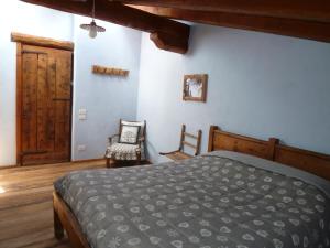 a bedroom with a bed and a chair in it at Agriturismo Barba Gust in Cesana Torinese
