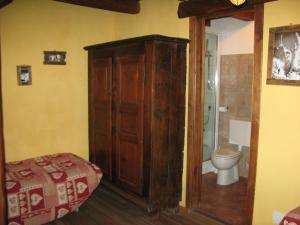 a bedroom with a bed and a toilet in a room at Agriturismo Barba Gust in Cesana Torinese