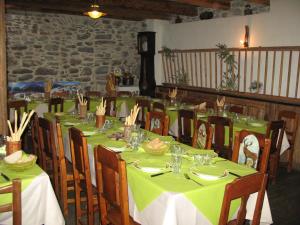 a dining room with green tables and chairs and a clock at Agriturismo Barba Gust in Cesana Torinese +68 photos