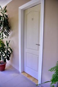 Una puerta blanca en una habitación con una planta en Hotel Ozieri en San Antonio Oeste