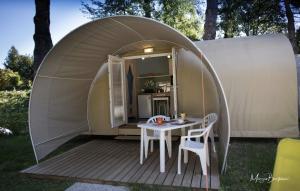 a small tent with a table and chairs on a deck at Camping Italia Lido in Castelletto sopra Ticino