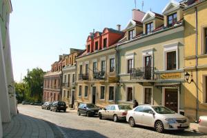 eine Gruppe von Autos, die auf einer Straße mit Gebäuden geparkt sind in der Unterkunft Apartamenty Furta Dominikańska in Sandomierz