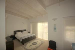a white bedroom with a bed and a window at B4 Waterfront in Swakopmund
