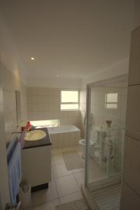 a bathroom with a sink and a tub and a toilet at B4 Waterfront in Swakopmund