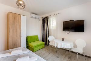 a living room with a table and a green chair at Apartments Batricevic in Herceg-Novi