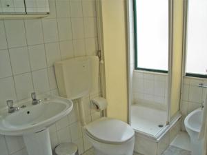 La salle de bains est pourvue de toilettes, d'un lavabo et d'une douche. dans l'établissement Residencial Roxi, à Lisbonne
