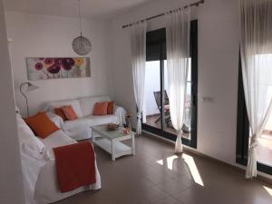 sala de estar con sofá blanco y mesa en Casa Anna en Conil de la Frontera