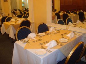 un comedor con una mesa con cubiertos y un espejo en The Hydro Hotel, en Douglas