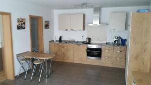 a kitchen with a table and a stove top oven at FeWo Brombachsee - Sonnentag West in Röttenbach