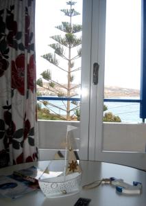 a window with a view of a pine tree at Corina Apartments in Sitia