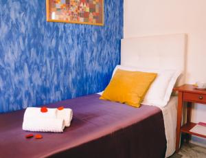 a bed with two towels on top of it at Diana Inn Accommodations in Pompei