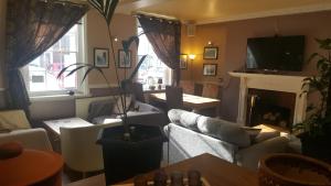 a living room with couches and a fireplace at Beaumond Cross Inn in Newark-on-Trent