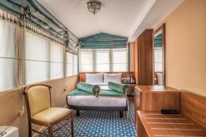 um quarto com uma cama, uma secretária e uma cadeira em Golden Tulip Borjomi em Borjomi