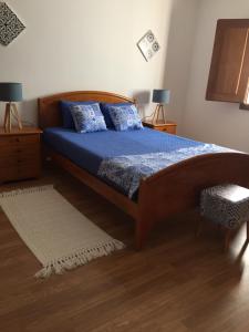 a bedroom with a bed with a blue comforter at Quinta da Vinha Morta in Lamego