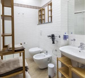 un bagno bianco con un water e un lavandino di Euforia Napoli - Tre Sedi - Three Locations a Napoli Altre 22 foto