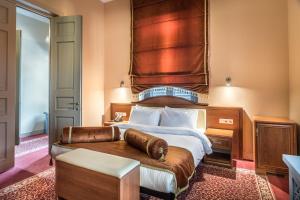 1 dormitorio con 1 cama grande y cabecero de madera en Golden Tulip Borjomi, en Borjomi
