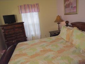 a bedroom with a bed and a dresser and a television at Westridge Pool Home in Davenport +7 photos