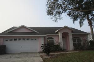 a house with a white garage door and a palm tree at Westridge Pool Home in Davenport