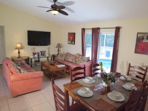 a living room with a table and chairs and a television at Westridge Pool Home in Davenport