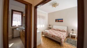 a bedroom with a bed and a bathroom with a sink at La Castellese in Aci Castello