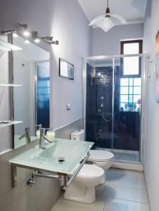 a bathroom with a sink and a toilet and a shower at La Castellese in Aci Castello