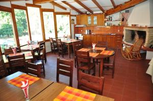 a restaurant with tables and chairs and a kitchen at Plaza Family Hotel in Smolyan
