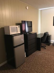 an office with a microwave and a refrigerator and a tv at Grizzly Motel in Swan Hills