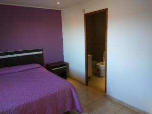 a bedroom with a purple bed and a bathroom at Casa quinta Camino al Sol in Junín +13 photos