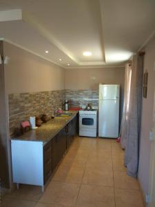 uma cozinha com um frigorífico branco e um fogão em Casa quinta Camino al Sol em Junín