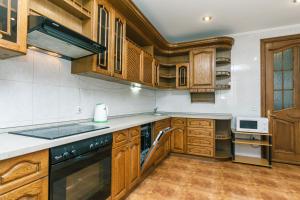 a kitchen with wooden cabinets and a stove top oven at VIP apartment near Olympic Stadium in Kyiv