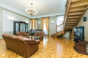 a living room with couches and a television and stairs at VIP apartment near Olympic Stadium in Kyiv