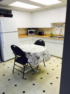 a kitchen with a table and two chairs in it at Grizzly Motel in Swan Hills