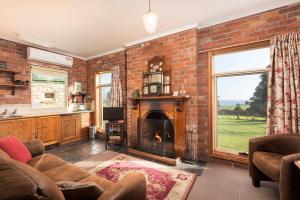 a living room with a brick wall and a fireplace at Killynaught Spa Cottages in Boat Harbour