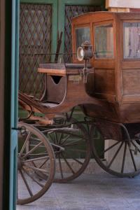 un viejo coche de madera está sentado en la calle en Palazzo Laura, en Morciano di Leuca