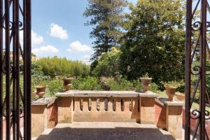 un cancello con una panca in pietra in un giardino di Palazzo Laura a Morciano di Leuca