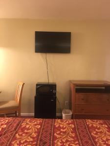 a hotel room with a bed and a television on the wall at Century Inn at LAX in Inglewood