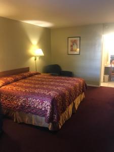 a hotel room with a bed and a lamp at Century Inn at LAX in Inglewood