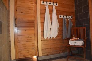 een badkamer met een houten deur en handdoeken bij Laasi Cozy Cottage in Kaigutsi +12 foto's