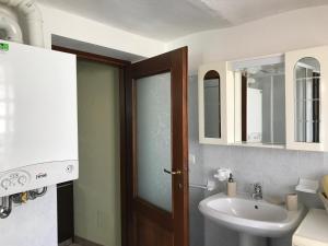a bathroom with a sink and a toilet and a door at B&B del Borgo in Mondovì +62 photos