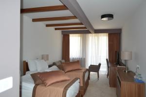 a bedroom with a bed and a couch and a desk at Apartments B&P in Jahorina