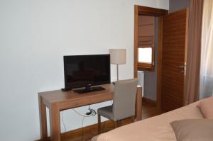 a bedroom with a desk with a television and a chair at Apartments B&P in Jahorina