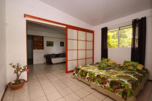 a room with a bed and a large window at Fare Kahaia in Fare