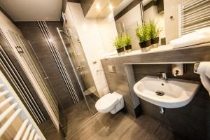 a bathroom with a sink and a toilet and a shower at Lawendowy Zdrój - Sanatorium Medyczne & Spa in Busko-Zdrój