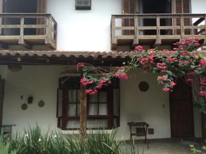 a house with flowers on the side of it at Conforto e Charme em Ilhabela in Ilhabela