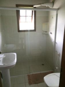 a bathroom with a shower and a toilet and a sink at Conforto e Charme em Ilhabela in Ilhabela