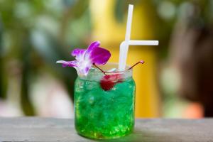 a drink with a purple flower and a straw at Golden Temple Villa in Siem Reap